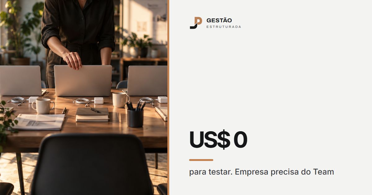 Cinco notebooks iguais enfileirados numa mesa compartilhada do escritório, com carregadores e canecas, e uma pessoa abrindo o do meio