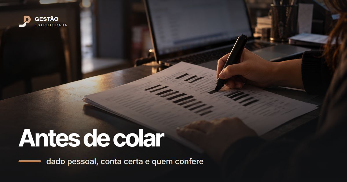 Mão passa marcador preto sobre colunas de uma lista impressa de clientes no balcão da loja, com o notebook aberto atrás, à luz do fim da tarde