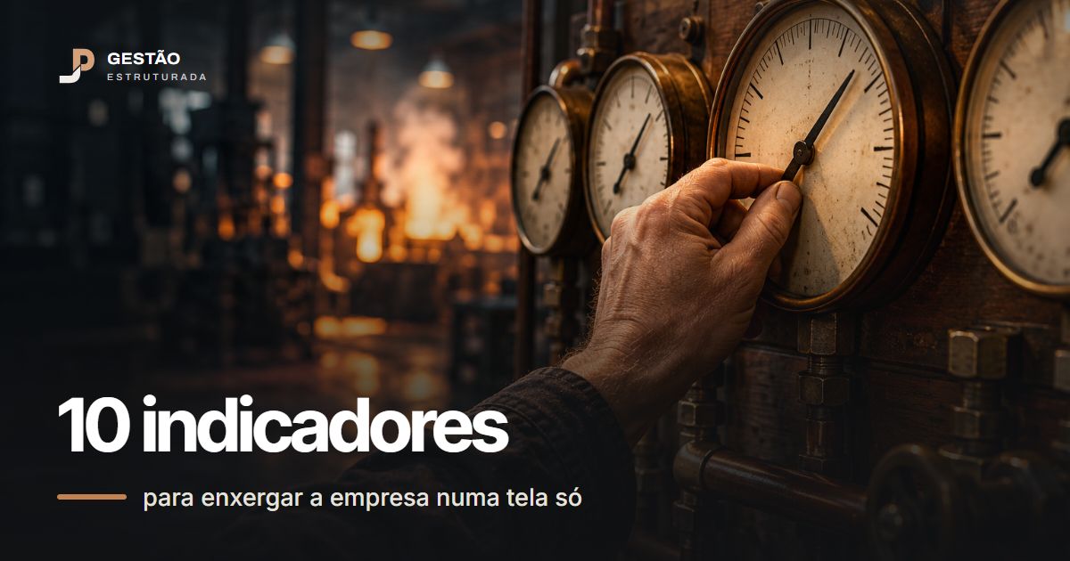Mão ajustando o ponteiro de um manômetro num painel de mostradores de latão, com o galpão da fábrica desfocado ao fundo