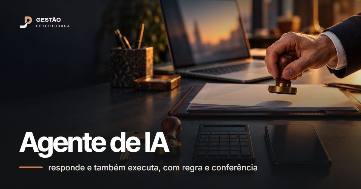 Mesa com ferramentas alinhadas, como chave, carimbo, calculadora e celular, e a mão de uma pessoa segurando o carimbo de aprovação, com um notebook ao fundo