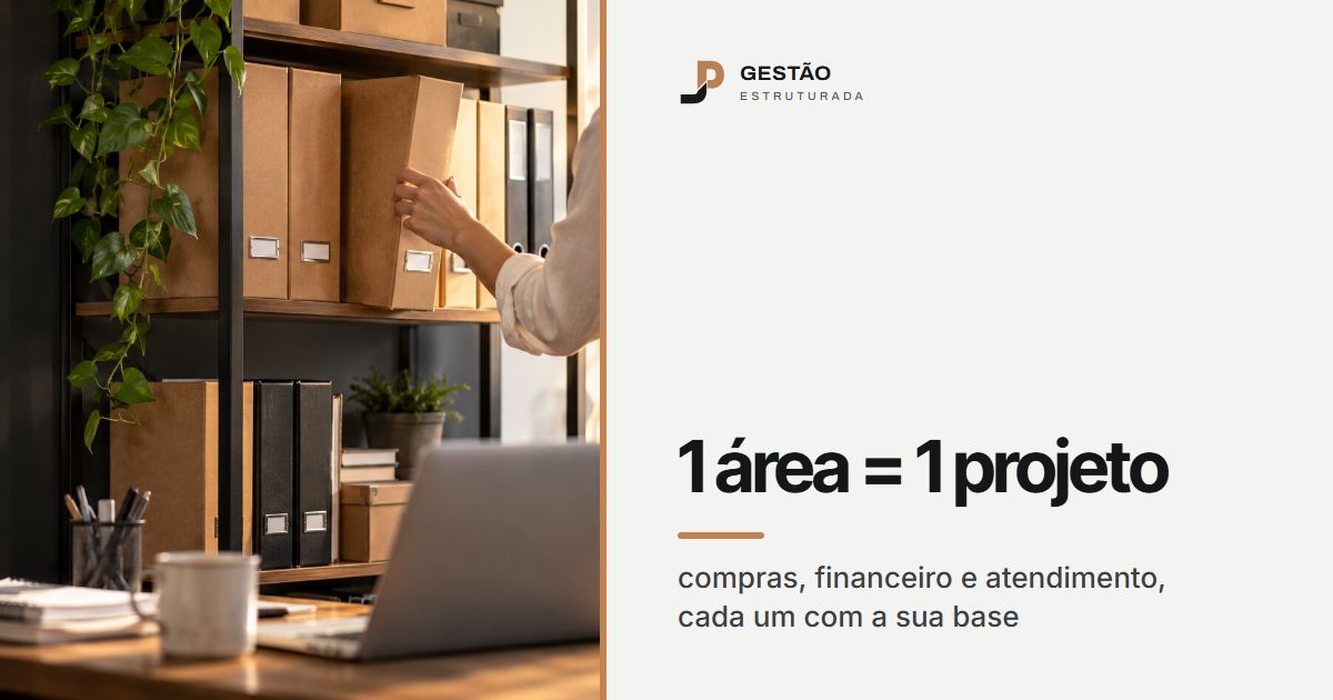 Mão guardando uma pasta numa estante de arquivos organizada por setor, ao lado de um notebook na mesa do escritório
